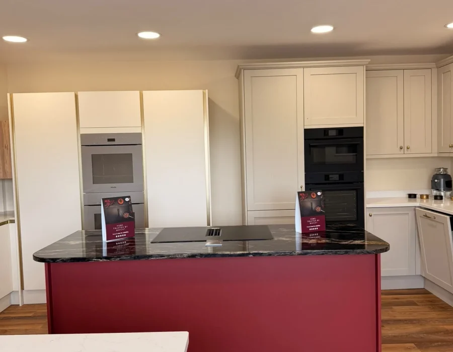 Bristol Appliance Centre showroom kitchen with a red island, dark granite worktop and built-in ovens