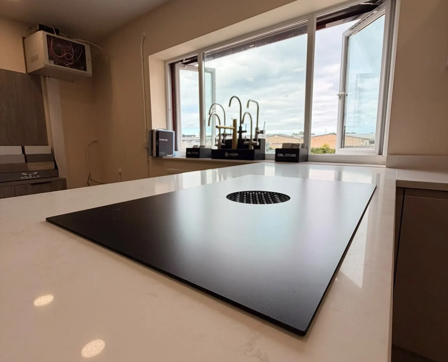 Venting induction hob set into a white quartz peninsula worktop in the showroom