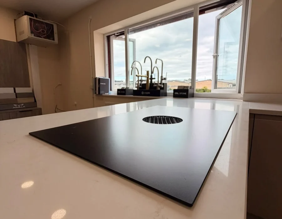 Venting induction hob set into a white quartz peninsula worktop in the showroom